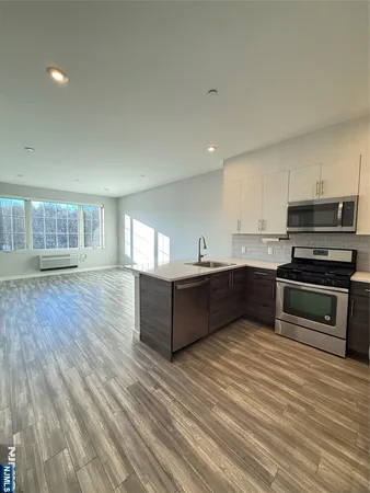 a kitchen with stainless steel appliances kitchen island granite countertop a stove a sink and a refrigerator