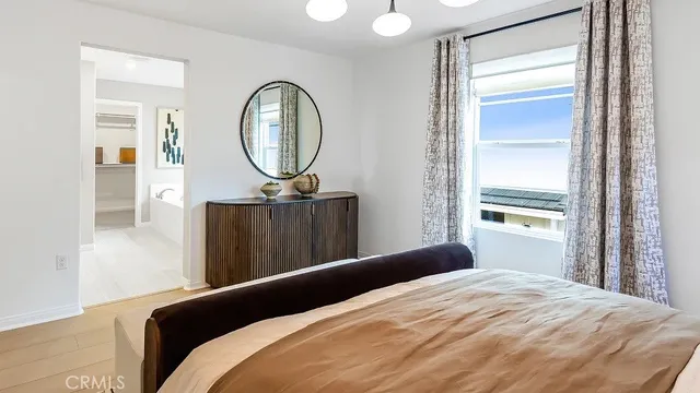 a bedroom with a bed a mirror and a window