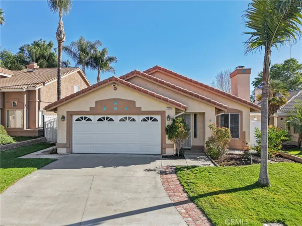 a front view of a house with a garden and plants