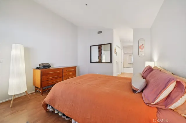 a bedroom with a bed and wooden floor