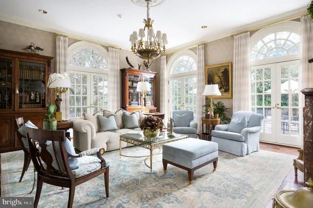 a living room with furniture a large window and a chandelier