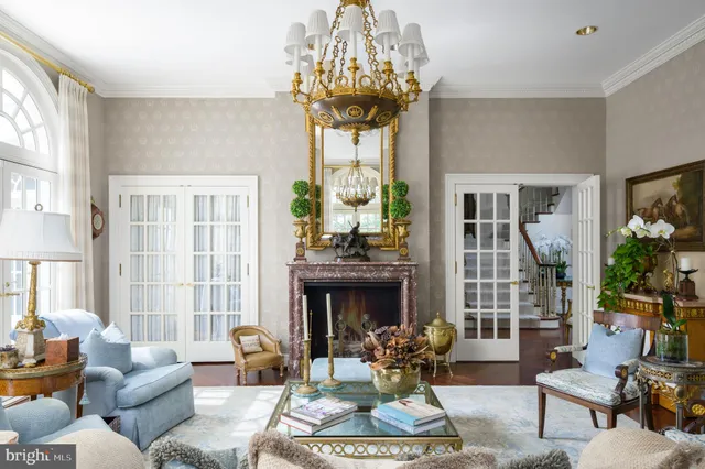 a living room with furniture a chandelier and a fireplace
