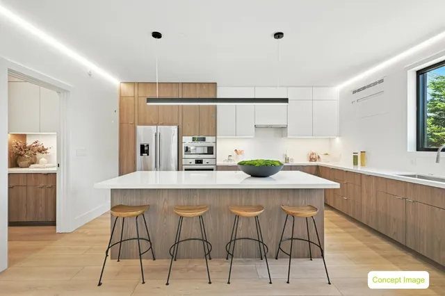 a kitchen with stainless steel appliances kitchen island a table chairs in it and white cabinets