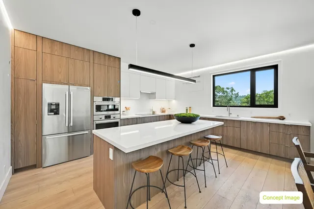 a kitchen with stainless steel appliances a table and chairs in it