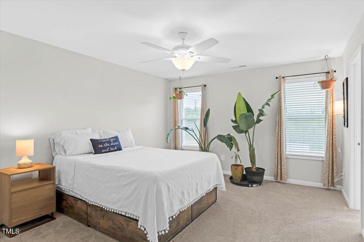 9834 Bitter Melon Drive Angier, NC 27501 - Photo 13 of 29 a bedroom with a bed and a chandelier