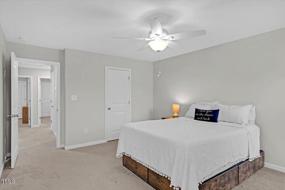 9834 Bitter Melon Drive Angier, NC 27501 - Photo 14 of 29 a bedroom with a bed and a chandelier