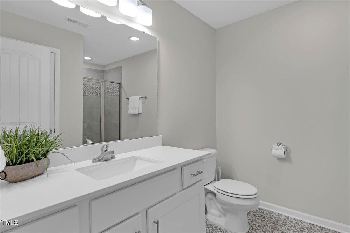 9834 Bitter Melon Drive Angier, NC 27501 - Photo 16 of 29 a bathroom with a sink toilet and a mirror