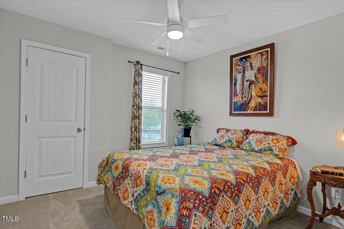 9834 Bitter Melon Drive Angier, NC 27501 - Photo 18 of 29 a bedroom with a bed and a chandelier