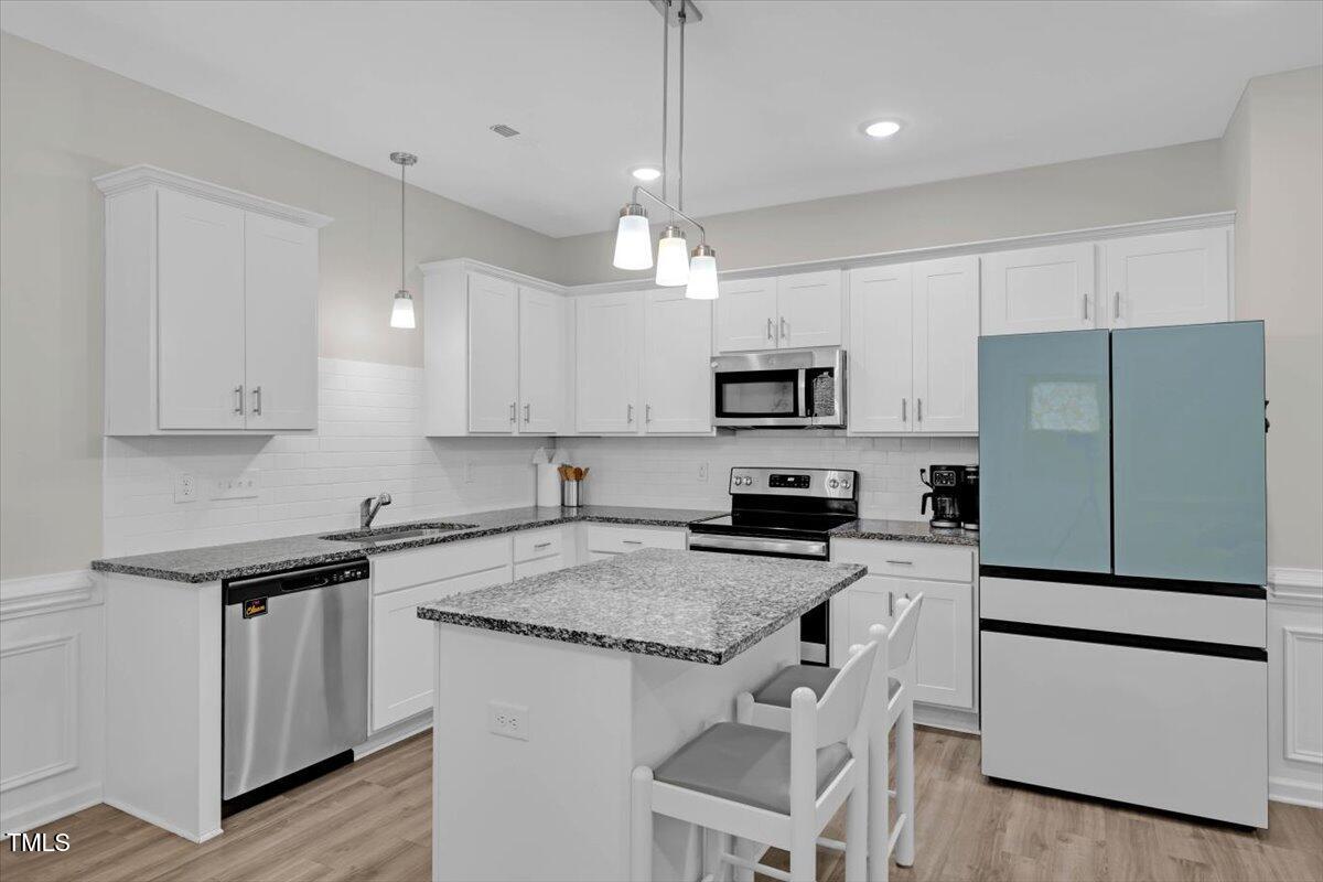 9834 Bitter Melon Drive Angier, NC 27501 - Photo 7 of 29 a kitchen with granite countertop white cabinets and white appliances