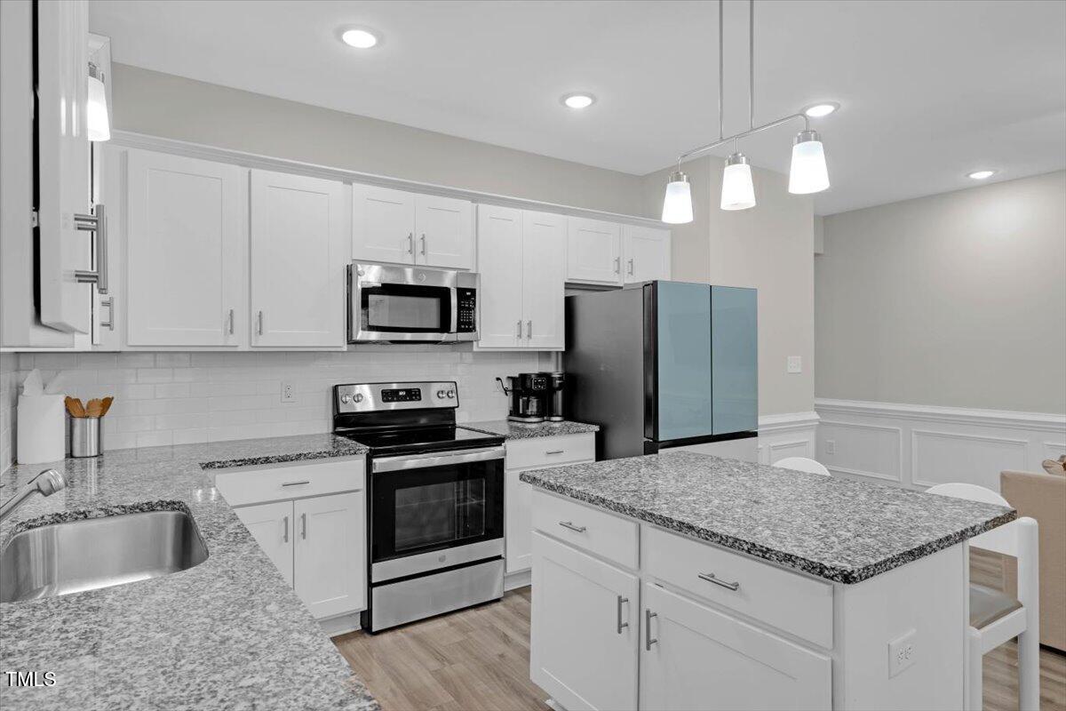 9834 Bitter Melon Drive Angier, NC 27501 - Photo 8 of 29 a kitchen with granite countertop stainless steel appliances cabinets a sink and a counter top space