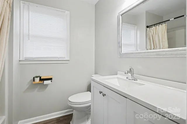 a bathroom with a sink a toilet and a window