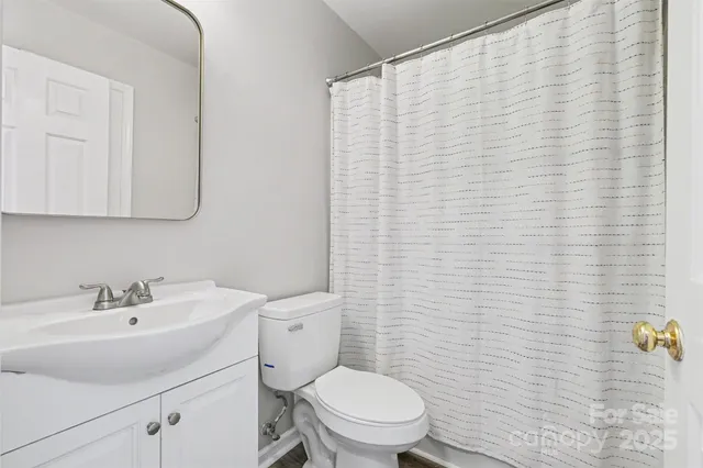 a bathroom with a sink a toilet and shower curtain