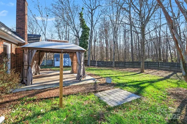 a view of a house with backyard and wooden fence