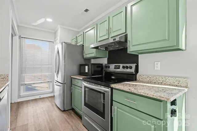 a kitchen with stainless steel appliances granite countertop a stove and a refrigerator