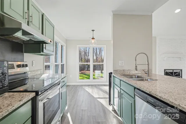 a kitchen with granite countertop a sink and a stove