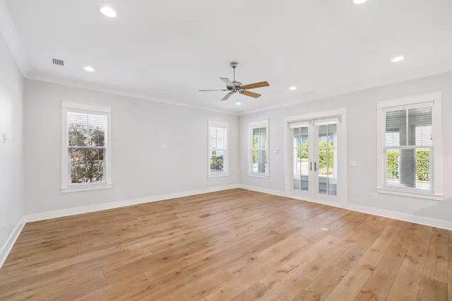 a view of an empty room with a kitchen and a window