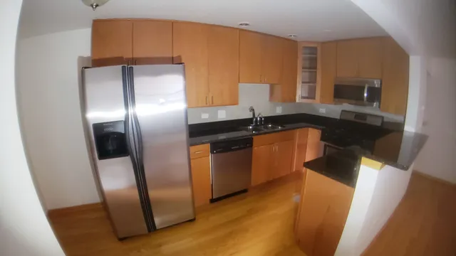 a kitchen with granite countertop a refrigerator a sink a stove and island