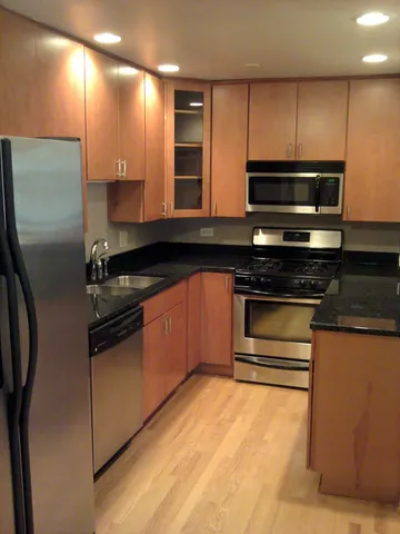 a kitchen with stainless steel appliances kitchen island granite countertop a stove a sink and a microwave