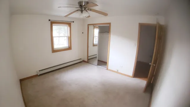 an empty room with windows and fan