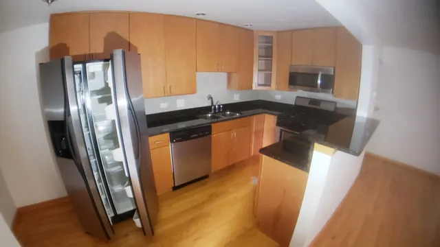 a kitchen with stainless steel appliances granite countertop a refrigerator a stove and a sink