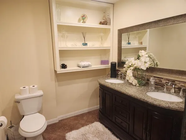 a bathroom with a granite countertop sink a toilet and a mirror