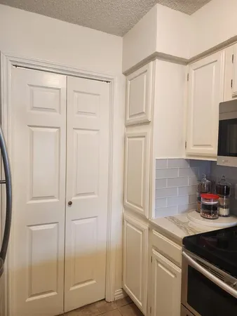 a kitchen with white cabinets and white appliances