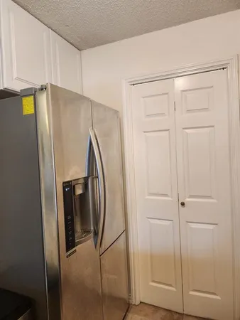 a view of a refrigerator in kitchen with stainless steel appliances wooden floor
