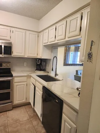 a kitchen with stainless steel appliances granite countertop a sink and cabinets