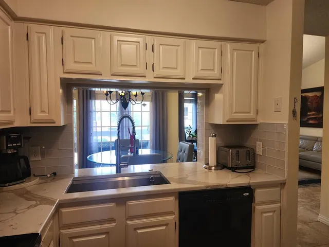 a kitchen with granite countertop a sink a stove and cabinets