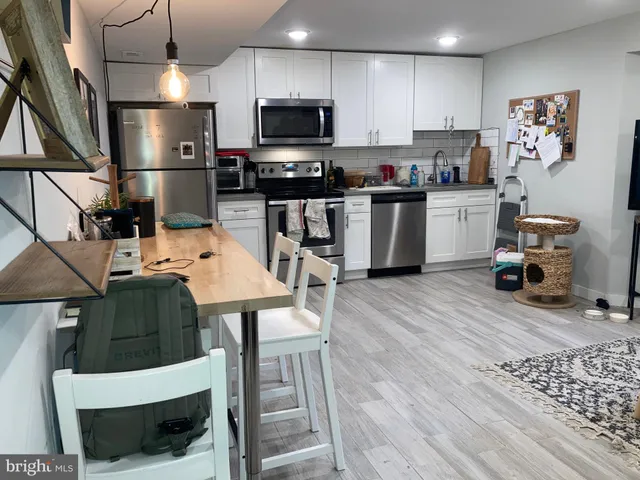 a kitchen with stainless steel appliances a stove a sink a microwave a refrigerator and cabinets