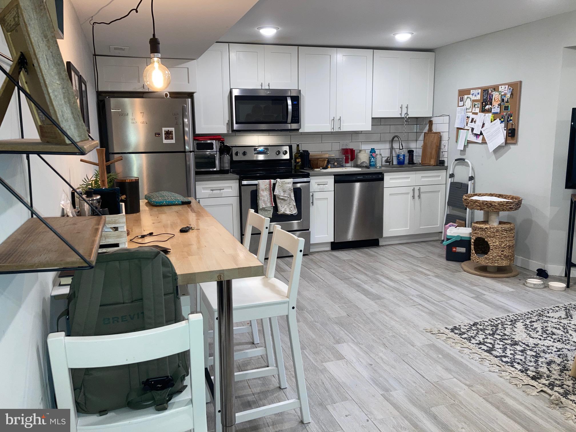 5301 Catharine Street, Unit 3 Philadelphia, PA 19143 - Photo 2 of 12 a kitchen with stainless steel appliances a stove a sink a microwave a refrigerator and cabinets
