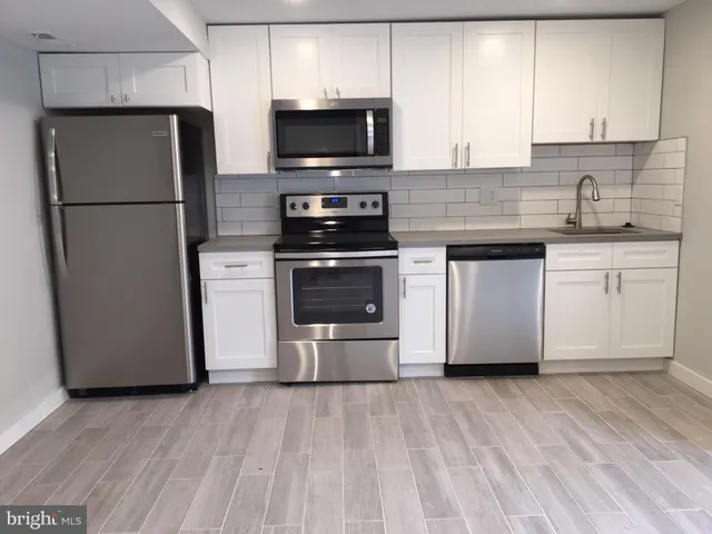 a kitchen with stainless steel appliances a refrigerator stove and microwave