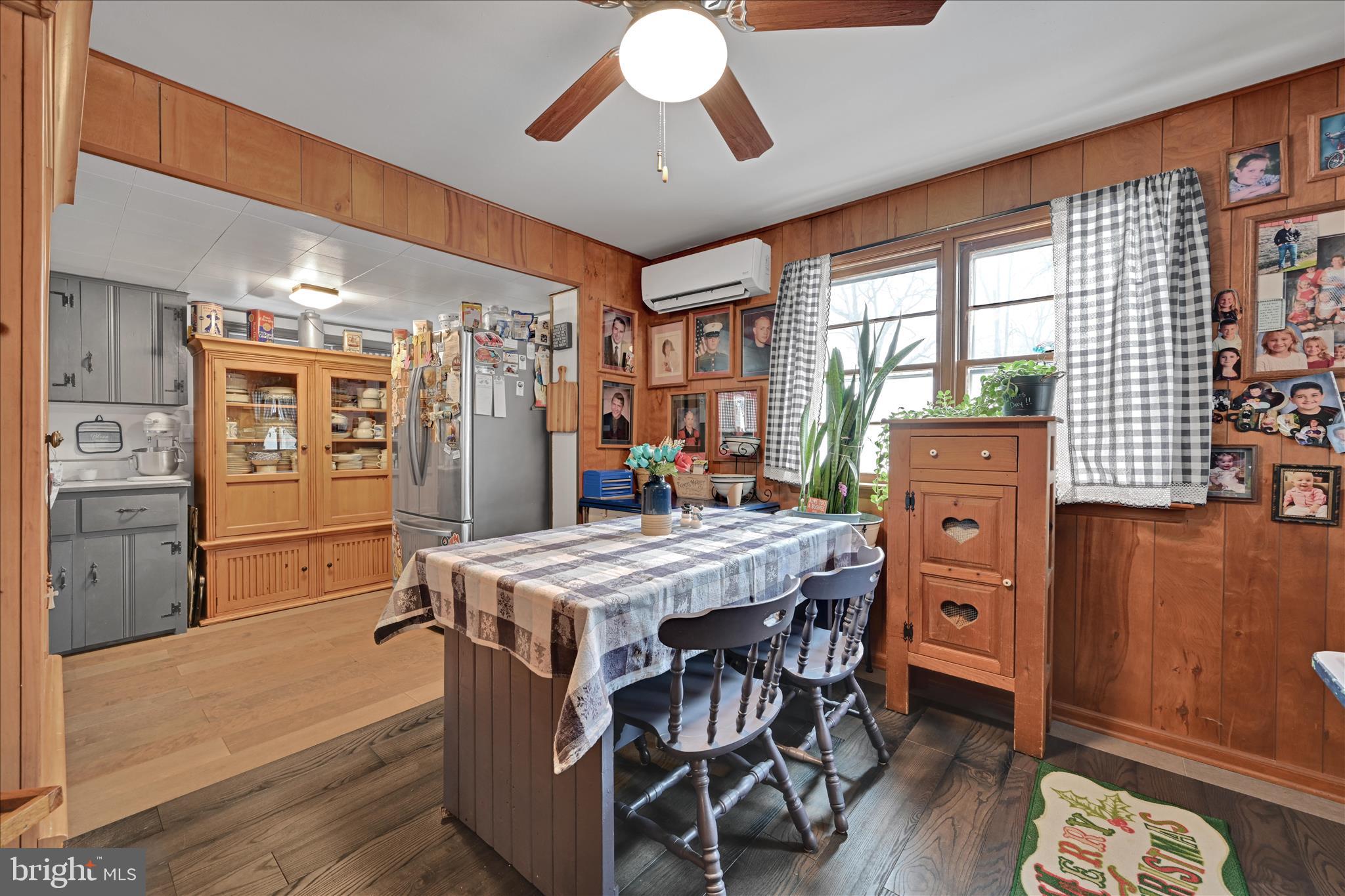 2440 Blue Ball Road Elkton, MD 21921 - Photo 11 of 30 a kitchen with stainless steel appliances kitchen island granite countertop a refrigerator a stove and a dining table with wooden floors