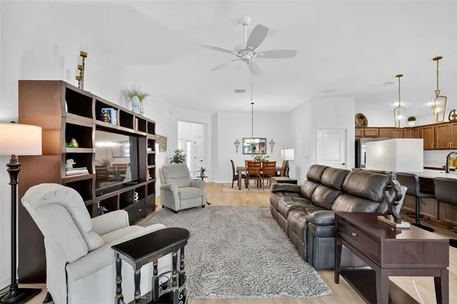 a living room with furniture a dining table and a wooden floor