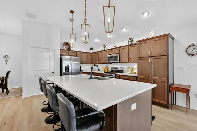 a kitchen with kitchen island a sink a stove and refrigerator