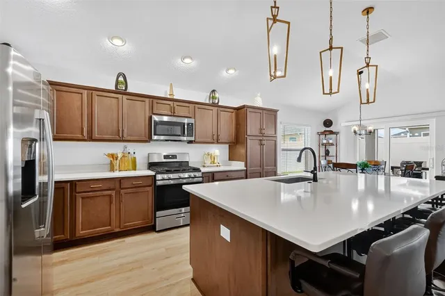 a kitchen with kitchen island granite countertop lots of counter top space and stainless steel appliances