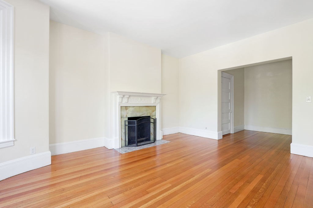 382 Commonwealth Avenue, Unit 24 Boston, MA 02215 - Photo 11 of 36 a view of empty room with wooden floor and fireplace