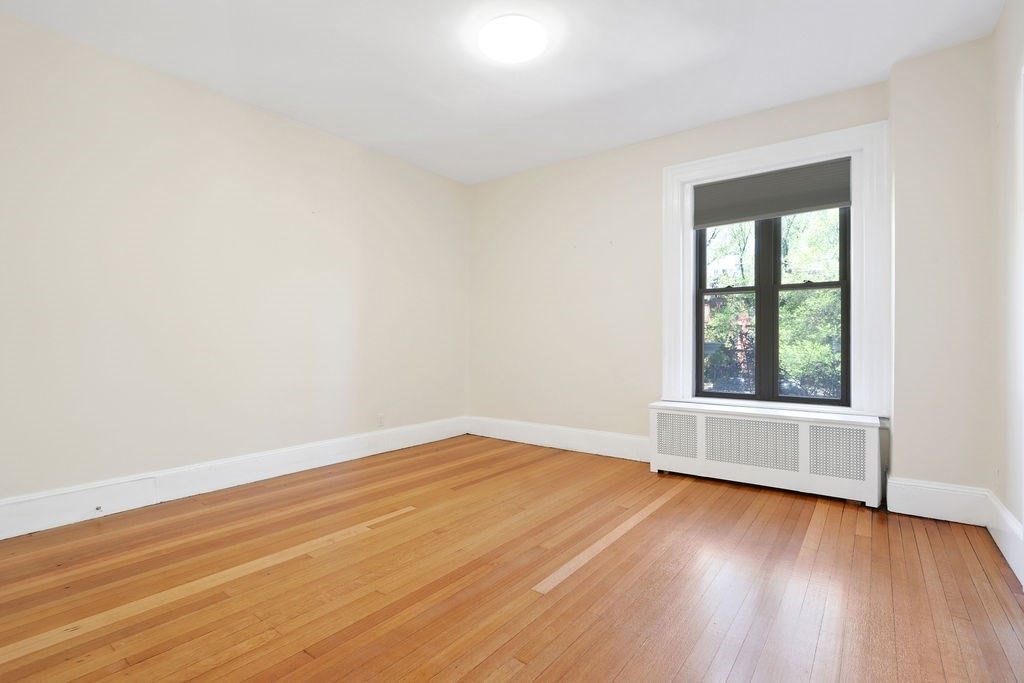 382 Commonwealth Avenue, Unit 24 Boston, MA 02215 - Photo 17 of 36 an empty room with wooden floor and windows