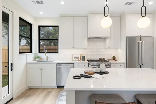 a kitchen with a sink a stove and cabinets