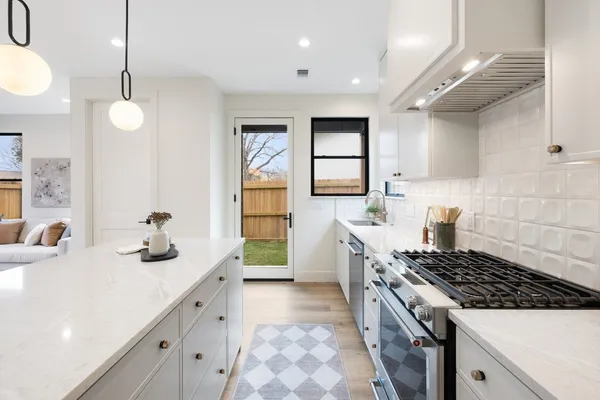 a kitchen with granite countertop a sink stove and cabinets