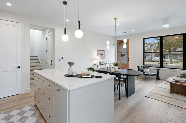 a kitchen with a sink a stove a dining table and chairs