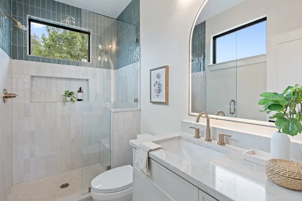 a bathroom with a sink a toilet a tub and shower