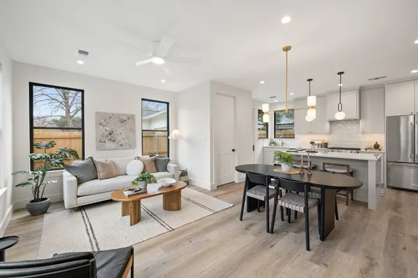 a living room with stainless steel appliances kitchen island granite countertop furniture and a wooden floor