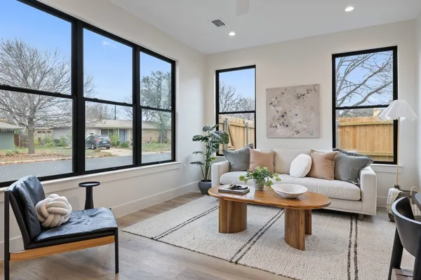 a living room with furniture a rug and a large window