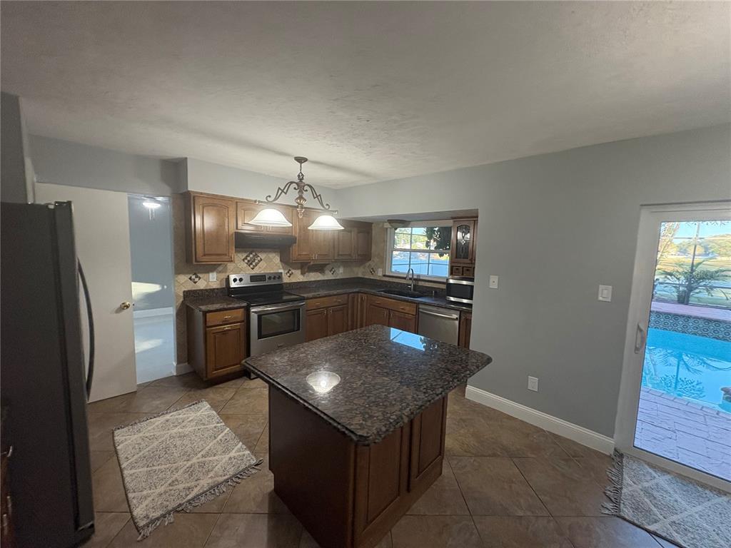 3904 Sweetleaf Drive Brandon, FL 33511 - Photo 16 of 34 a kitchen with stainless steel appliances granite countertop a sink stove and refrigerator