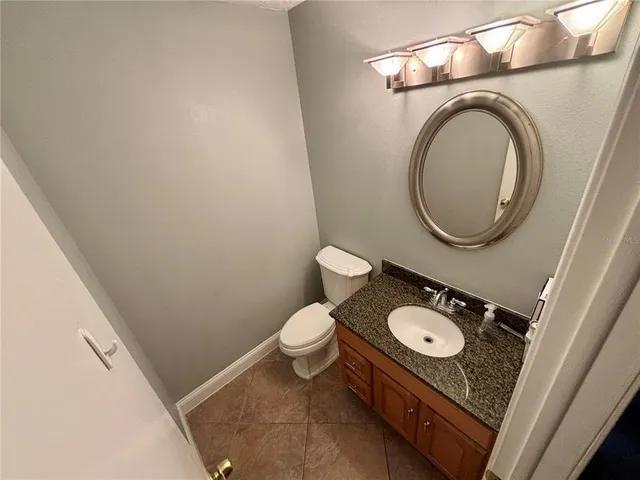 a bathroom with a toilet mirror and vanity