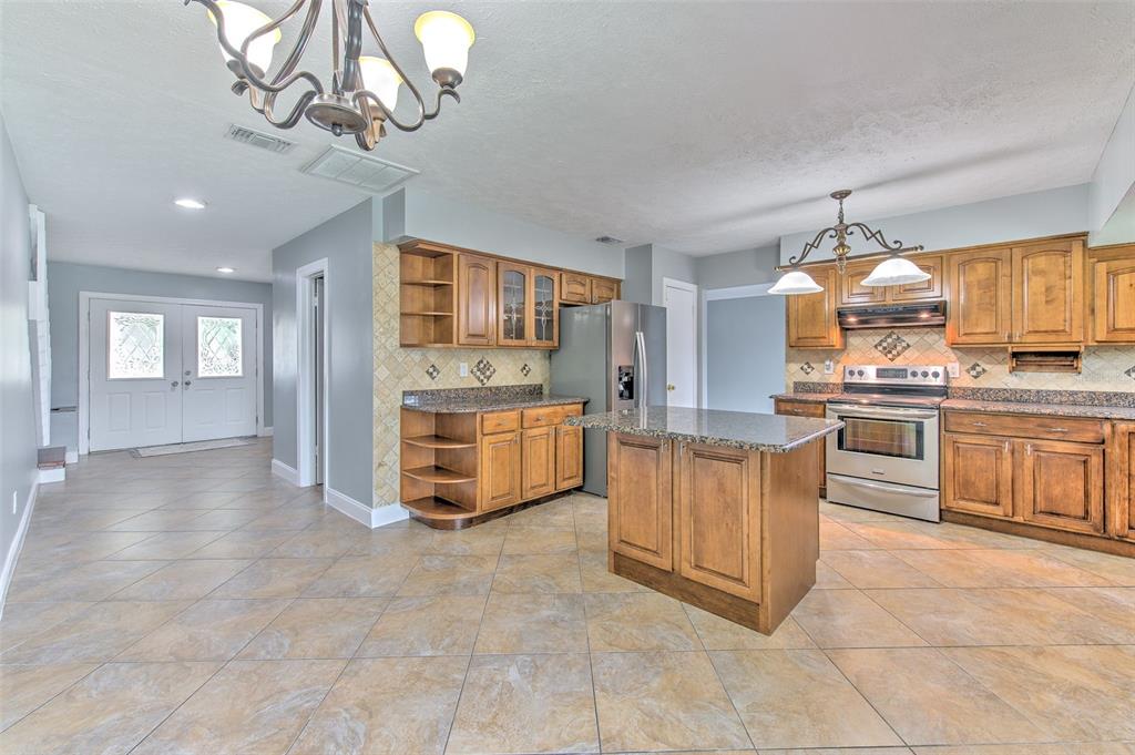 3904 Sweetleaf Drive Brandon, FL 33511 - Photo 24 of 66 a kitchen with a stove a sink and chandelier