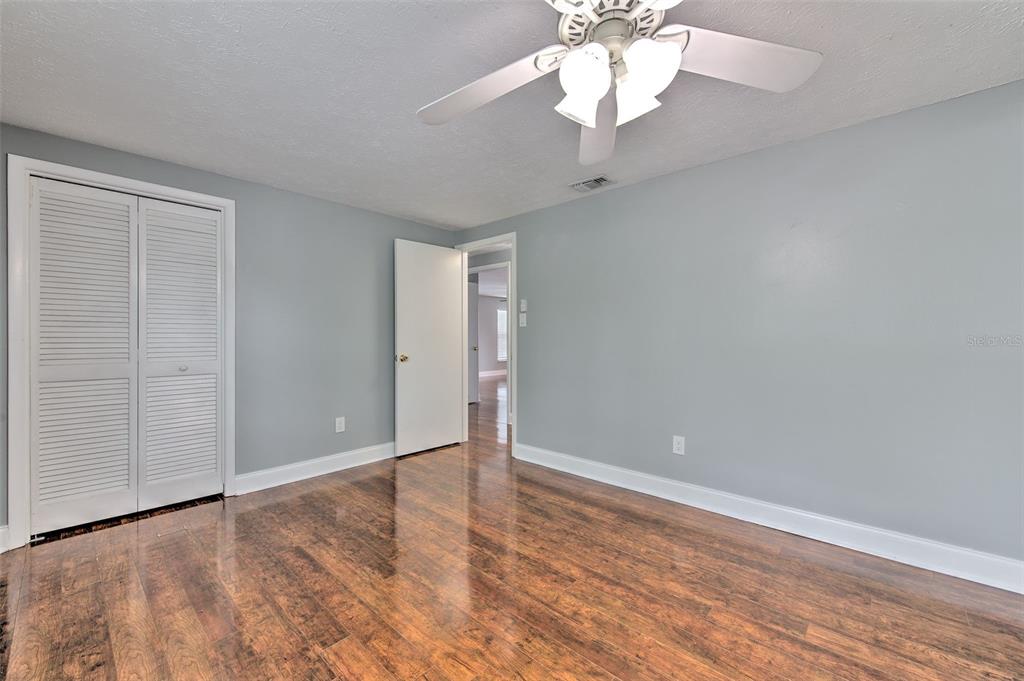 3904 Sweetleaf Drive Brandon, FL 33511 - Photo 41 of 66 an empty room with wooden floor chandelier fan and entryway