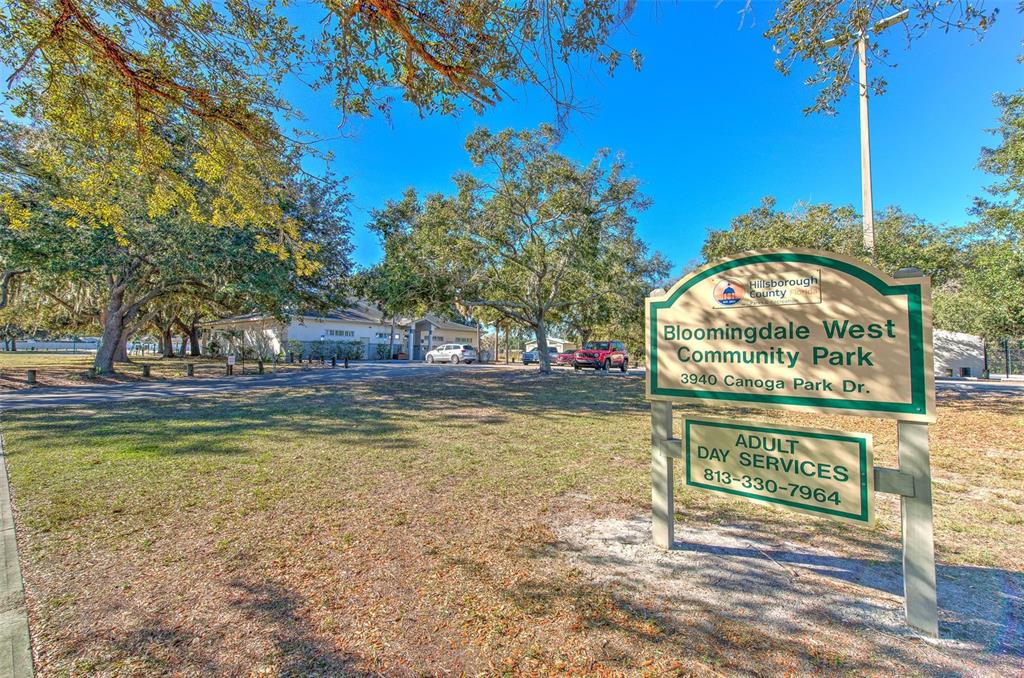 3904 Sweetleaf Drive Brandon, FL 33511 - Photo 60 of 66 a view of swimming pool with a bench and trees in the background