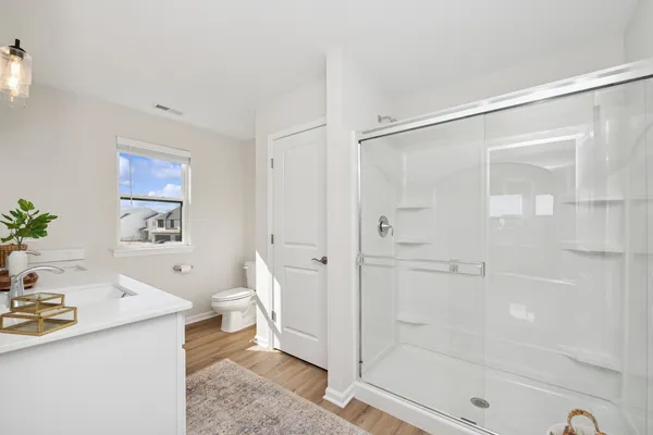 a bathroom with a sink a toilet and shower